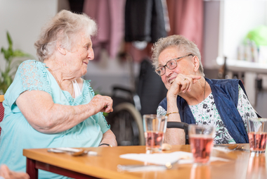 Zwei lachende ältere Damen im Seniorencafe.